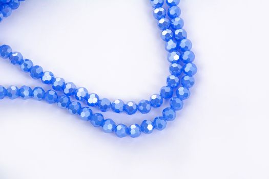 Beautiful blue Glass Sparkle Crystal Isoalted Beads on white background. Use for diy beaded jewelry. Space for text