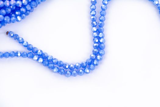 Beautiful blue Glass Sparkle Crystal Isoalted Beads on white background. Use for diy beaded jewelry. Space for text