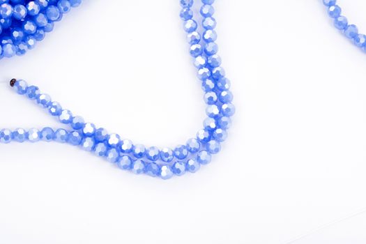 Beautiful blue Glass Sparkle Crystal Isoalted Beads on white background. Use for diy beaded jewelry. Space for text