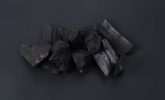 Group of charcoal black color made from real wood in studio close-up shot which use for cooking or absorb odor in room or refrigerator. And use in some cosmetic industry.