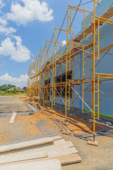 Vertical shot of scaffolding in front of new commercial construction.

