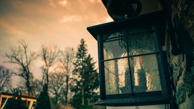 An Old-Fashioned Glass Lamp Hanging on the Side of a Home