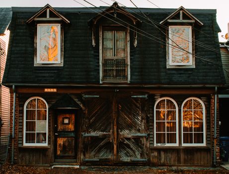 An Old Rustic House Made of Textured Wood with a Large Barn Door