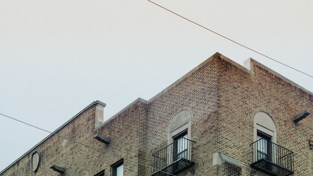 The Top of an Old-Fashioned Brick Apartment Building on a Gray Overcast Sky