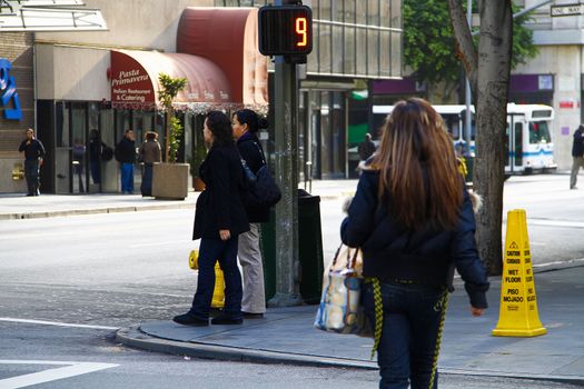 Los Angeles,CA/USA - Nov,03,2018 : Back view of young girls walking at an intersection and women waiting for a signal