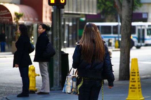 Los Angeles,CA/USA - Nov,03,2018 : Back view of young girls walking at an intersection and women waiting for a signal