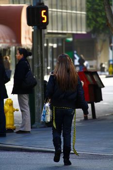 Los Angeles,CA/USA - Nov,03,2018 : Back view of young girls walking at an intersection and women waiting for a signal