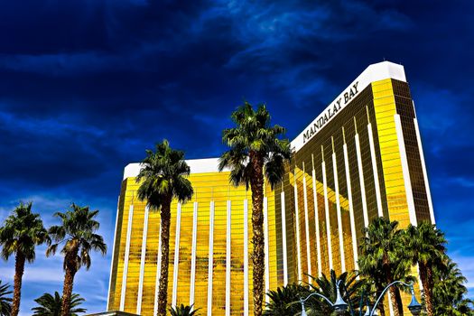 Las Vegas, NV/USA - Sep 15, 2018; Enormous Mandalay Bay Hotel Resort and Casino Las Vegas with beautifully landscaped entrance to modern architectural gold glass facade of building.