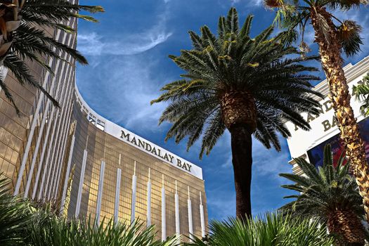 Las Vegas, NV/USA - Sep 15, 2018; Enormous Mandalay Bay Hotel Resort and Casino Las Vegas with beautifully landscaped entrance to modern architectural gold glass facade of building.