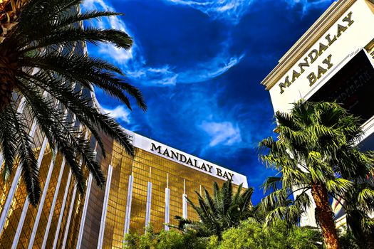 Las Vegas, NV/USA - Sep 15, 2018; Enormous Mandalay Bay Hotel Resort and Casino Las Vegas with beautifully landscaped entrance to modern architectural gold glass facade of building.