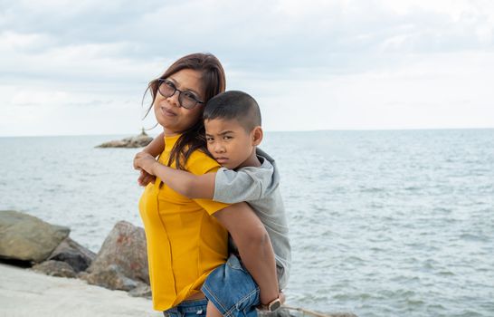 Portrait of mother and son on a sea background.