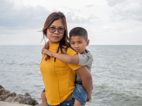 Portrait of mother and son on a sea background.