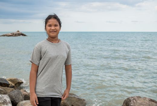 Portrait of a girl standing with a sea background.