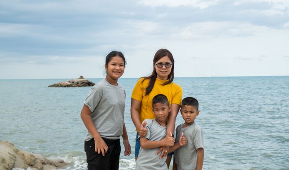 Portraits of mothers and children standing on the rock with the background of the sea.