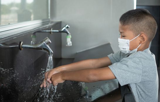 Boy wearing a mask Washing hands in public toilets