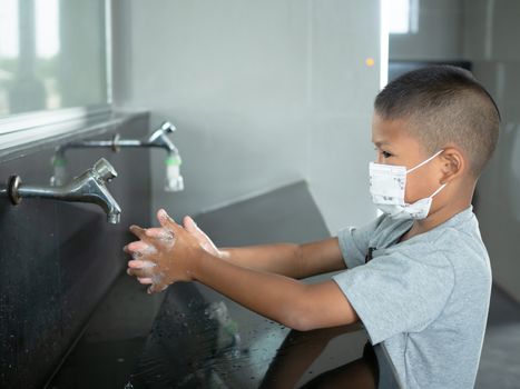 Boy wearing a mask Washing hands in public toilets