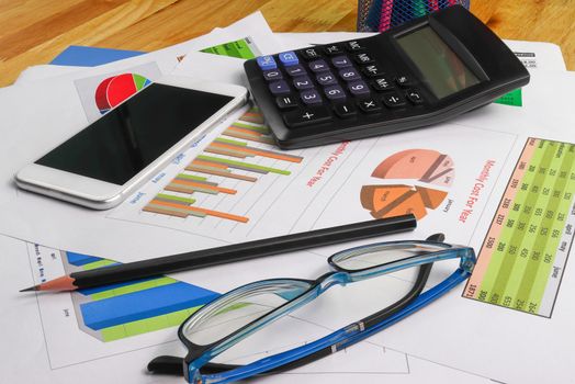 business paper graphs calculator pencil glasses with charts report, concept financial planning, concepts business and cost.