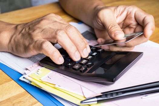 Hand of man use calculators with credit card concept Calculating credit card expenses 