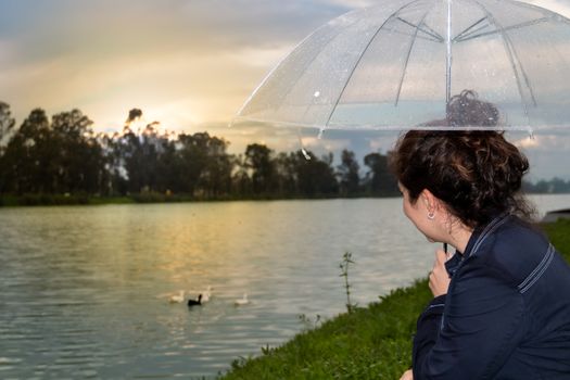 Real woman watching the sunset on a lake. summer