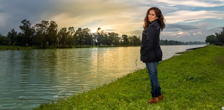 Real woman watching the sunset on a lake. summer