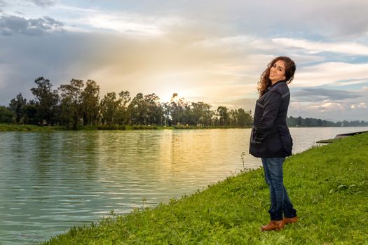 Real woman watching the sunset on a lake. summer