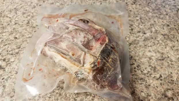 frozen raw beef meat in plastic bag on counter