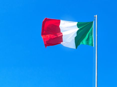 Italy flag waving against a blue sky background. Tricolor flag. Copy Space.