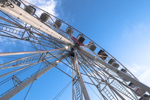 Ferris wheel on cloudy sky background. Bottom view. Copy space.