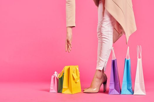 shopping bags female feet in shoes Shopaholic pink background. High quality photo