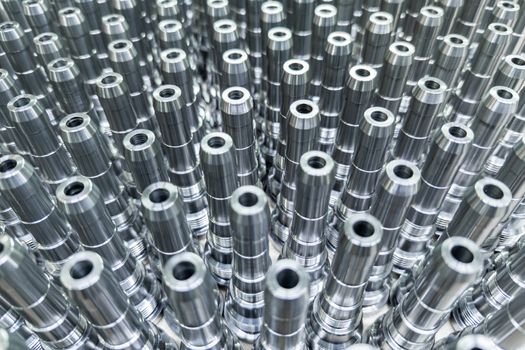 Shiny long steel parts full frame background, clean steel threaded rods after fine cnc turning.