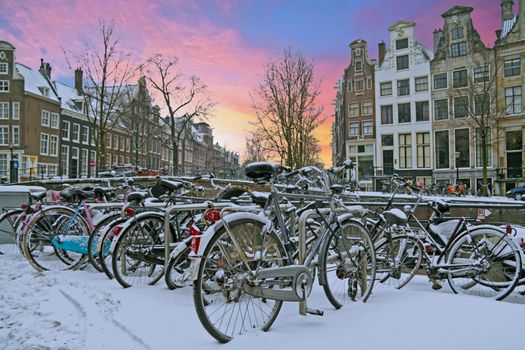 Snowy Amsterdam in winter in the Netherlands at sunset