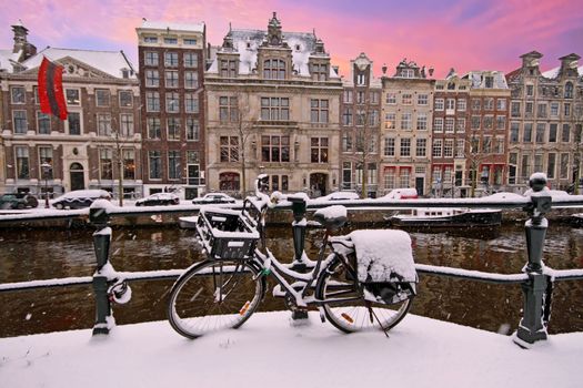 Snowy Amsterdam in winter in the Netherlands at sunset