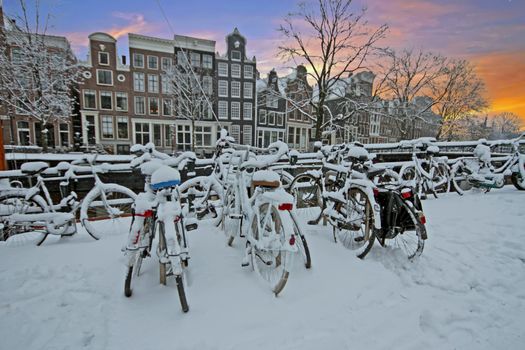 City scenic from snowy Amsterdam in the Netherlands at sunset