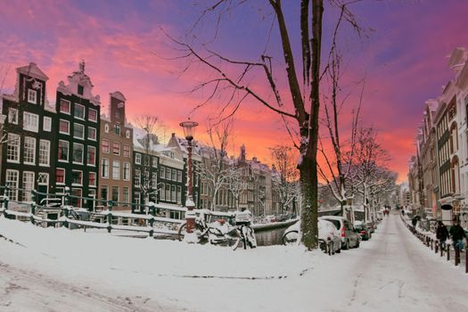 City scenic from snowy Amsterdam in the Netherlands at sunset