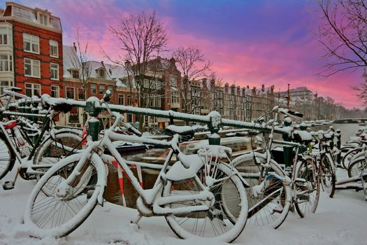 City scenic from snowy Amsterdam in the Netherlands at sunset