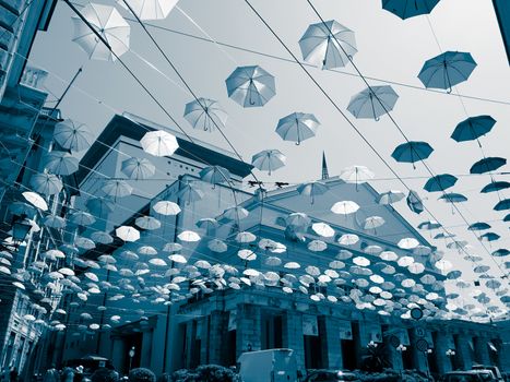 Genova, Italy - 0/29/2020: Multicolored umbrellas against the sky, street decorated. LGBT flag. Rainbow love concept. Human rights and tolerance.