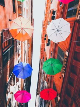 Genova, Italy - 0/29/2020: Multicolored umbrellas against the sky, street decorated. LGBT flag. Rainbow love concept. Human rights and tolerance.