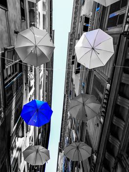 Genova, Italy - 0/29/2020: Multicolored umbrellas against the sky, street decorated. LGBT flag. Rainbow love concept. Human rights and tolerance.