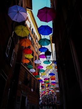 Genova, Italy - 0/29/2020: Multicolored umbrellas against the sky, street decorated. LGBT flag. Rainbow love concept. Human rights and tolerance.