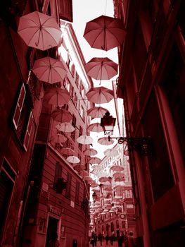 Genova, Italy - 0/29/2020: Multicolored umbrellas against the sky, street decorated. LGBT flag. Rainbow love concept. Human rights and tolerance.