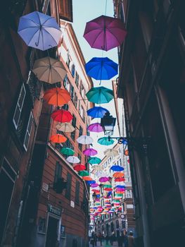 Genova, Italy - 0/29/2020: Multicolored umbrellas against the sky, street decorated. LGBT flag. Rainbow love concept. Human rights and tolerance.