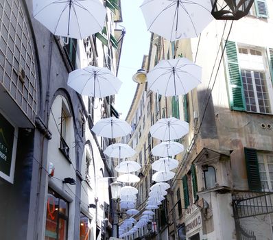 Genova, Italy - 0/29/2020: Multicolored umbrellas against the sky, street decorated. LGBT flag. Rainbow love concept. Human rights and tolerance.