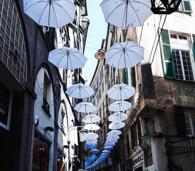 Genova, Italy - 0/29/2020: Multicolored umbrellas against the sky, street decorated. LGBT flag. Rainbow love concept. Human rights and tolerance.