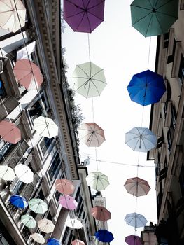 Genova, Italy - 0/29/2020: Multicolored umbrellas against the sky, street decorated. LGBT flag. Rainbow love concept. Human rights and tolerance.