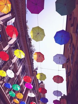 Genova, Italy - 0/29/2020: Multicolored umbrellas against the sky, street decorated. LGBT flag. Rainbow love concept. Human rights and tolerance.