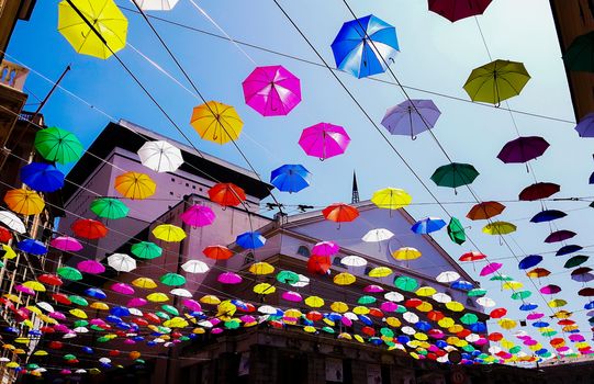 Genova, Italy - 0/29/2020: Multicolored umbrellas against the sky, street decorated. LGBT flag. Rainbow love concept. Human rights and tolerance.