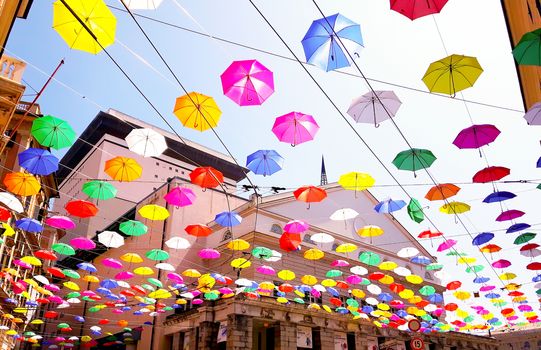 Genova, Italy - 0/29/2020: Multicolored umbrellas against the sky, street decorated. LGBT flag. Rainbow love concept. Human rights and tolerance.