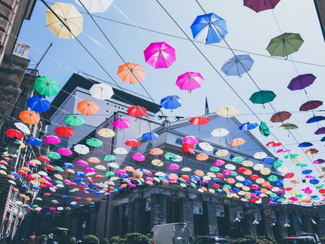 Genova, Italy - 0/29/2020: Multicolored umbrellas against the sky, street decorated. LGBT flag. Rainbow love concept. Human rights and tolerance.