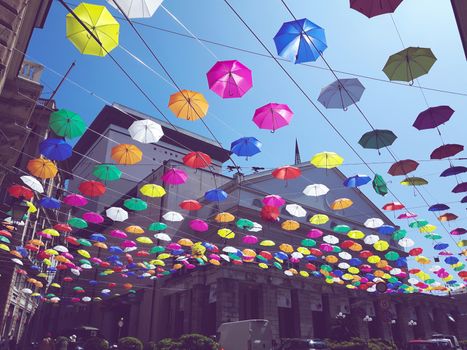 Genova, Italy - 0/29/2020: Multicolored umbrellas against the sky, street decorated. LGBT flag. Rainbow love concept. Human rights and tolerance.