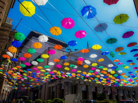 Genova, Italy - 0/29/2020: Multicolored umbrellas against the sky, street decorated. LGBT flag. Rainbow love concept. Human rights and tolerance.